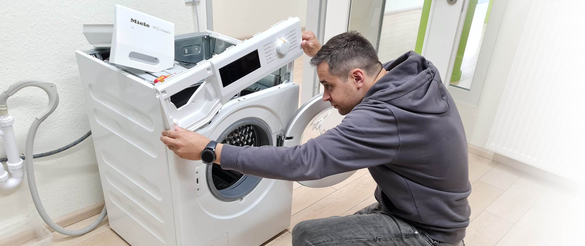 Bild vom Eigentümer beim Reparieren einer Waschmaschine